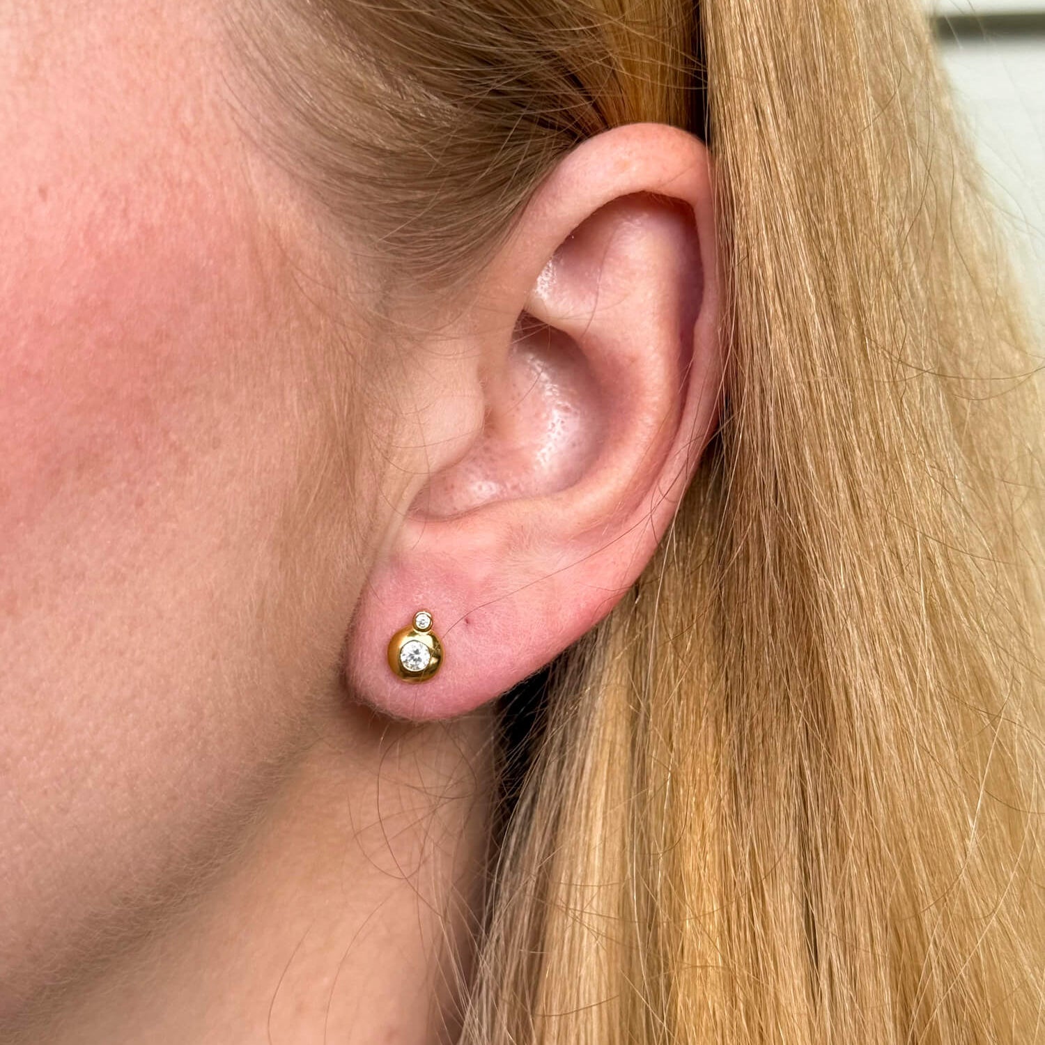 Model wearing gold-plated on sterling silver double bezel zirconia stud earrings, delicate minimalist sparkle. - Solinu Jewellery 