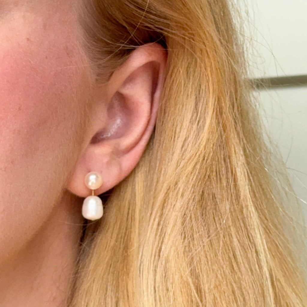 Model wearing gold-plated on sterling silver drop earrings featuring double freshwater pearls, elegant timeless occasion style. - Solinu Jewellery 