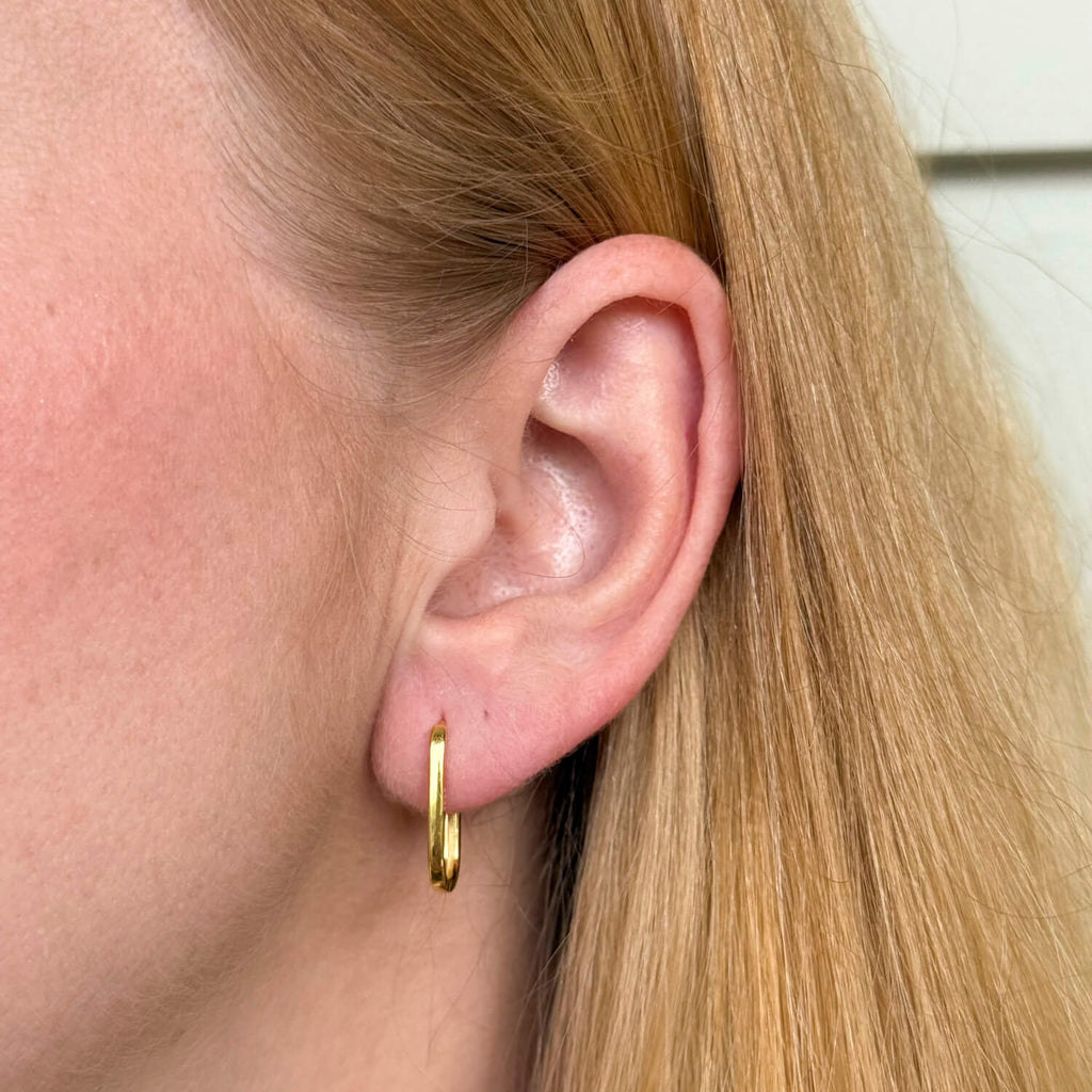 Model wearing gold-plated on sterling silver elongated hoop earrings with sleek minimalist silhouette, everyday jewellery essential. - Solinu Jewellery 