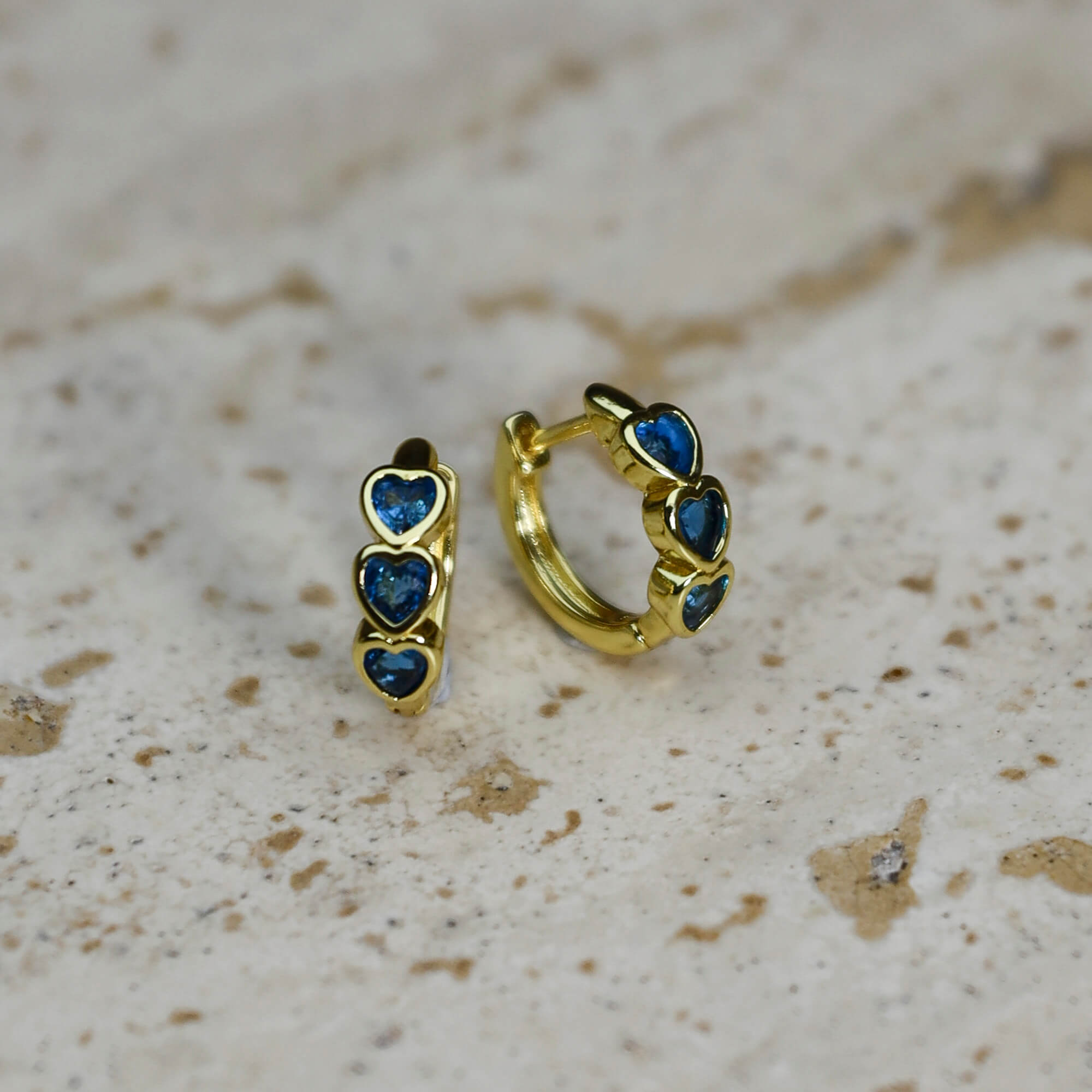 Gold plated huggie earrings with bezel-set blue heart, casual everyday jewellery. - Solinu Jewellery